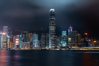 Illuminated buildings in city against sky at night