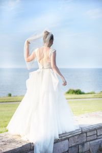 Rear view of woman with umbrella standing on beach