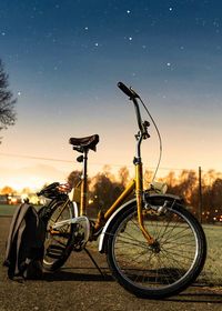Bicycle parked on field at night