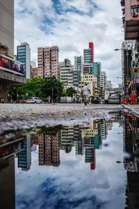 Reflection of buildings in canal against sky