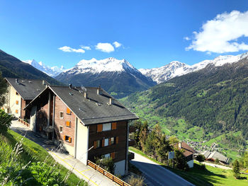 Houses by snowcapped mountains against sky