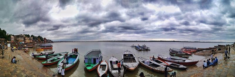 Panoramic view of boats moored in sea against sky