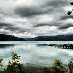 Scenic view of calm lake against cloudy sky