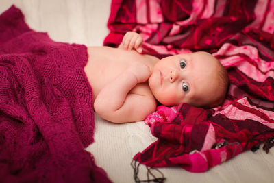 Portrait of cute baby boy lying on bed