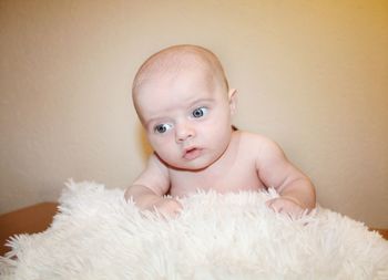 Close-up of cute baby boy against wall at home