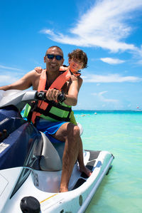 Father and son sitting on jet boat