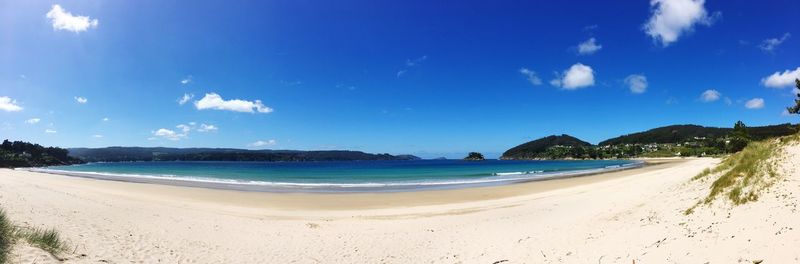 Panoramic view of beach against blue sky