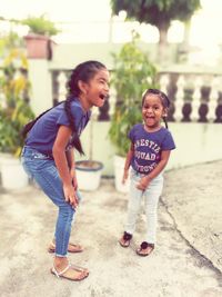 Full length of happy friends standing on footpath