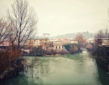 River with buildings and bare trees in background