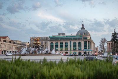 Buildings in city against cloudy sky