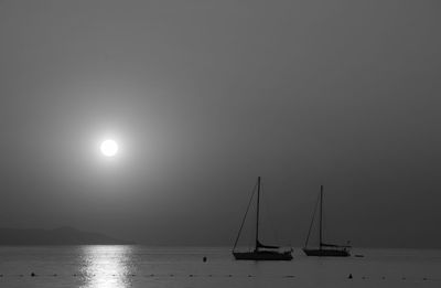 Sailboats sailing in sea against sky