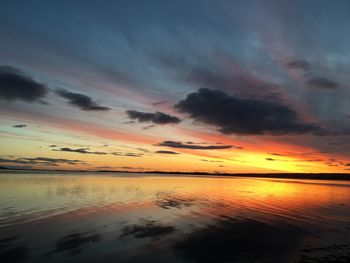 Scenic view of sea against dramatic sky during sunset