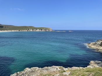 Scenic view of sea against clear blue sky