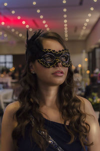 Beautiful woman wearing eye mask during party