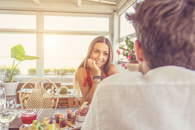 Portrait of smiling young woman sitting on table