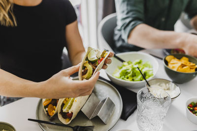 Woman assembling tacos on plate