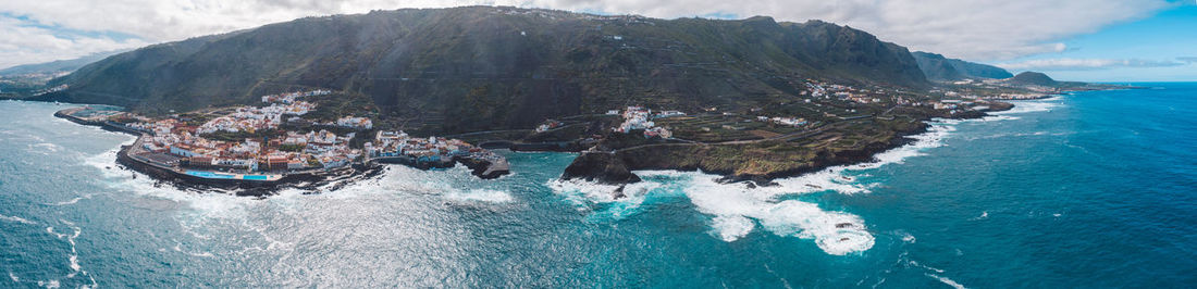 Panoramic view of sea and mountains against sky