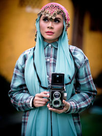 Beautiful asian female posing with a retro camera