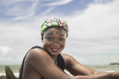 Happy africa woman with headdress from ghana on a beach on the coast of axim ghana west africa