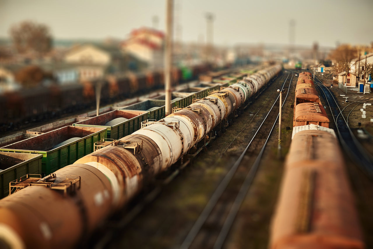 track, transport, train, rail transportation, railroad track, railway, transportation, architecture, vehicle, sky, no people, selective focus, morning, nature, industry, outdoors, mode of transportation, city, day, business, public transport, in a row