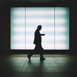 Side view of silhouette man standing against window