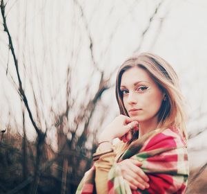 Portrait of young woman against plants