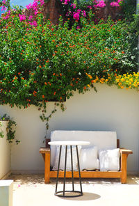 Empty chairs and table against white wall