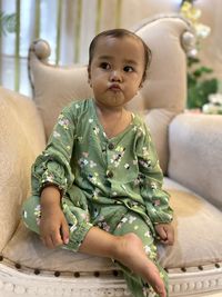 Portrait of boy sitting on sofa at home