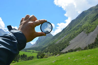 Cropped hand holding loop against mountains