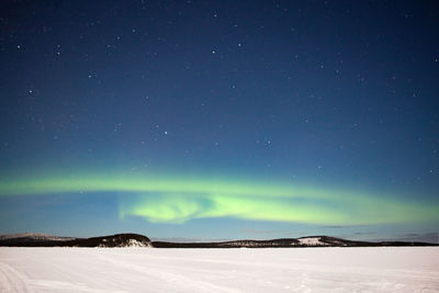 Scenic view of snowcapped landscape against sky at night