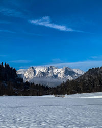 Scenic view of snowcapped mountains against blue sky