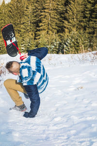 Man learning to snowboard during winter