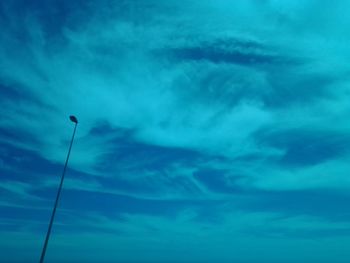 Low angle view of street light against dramatic sky