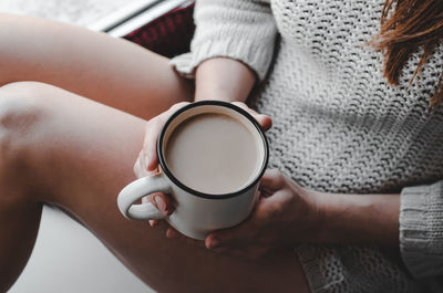 Midsection of woman holding coffee cup