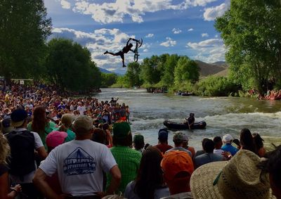 Group of people enjoying in water against sky