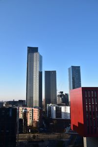 Modern buildings against clear blue sky