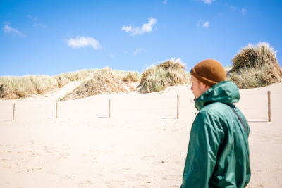 Rear view of woman walking on mountain against sky