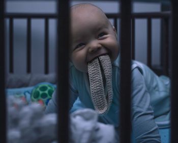 Portrait of cute baby boy in crib at home