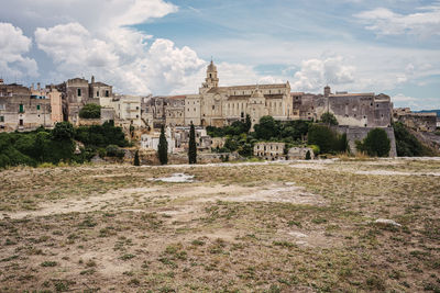 Buildings in city against cloudy sky