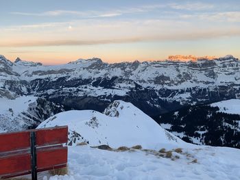 Scenic view of snowcapped mountains against sky during sunset