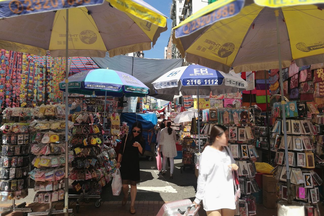 PEOPLE STANDING IN MARKET STALL