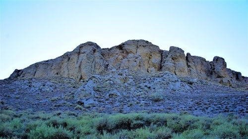 Low angle view of rocks against clear sky