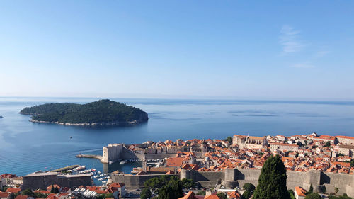 High angle view of townscape by sea against clear sky