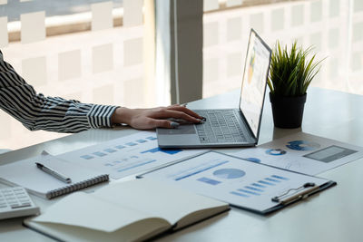 Midsection of businesswoman working on table