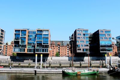 Buildings in city against clear blue sky