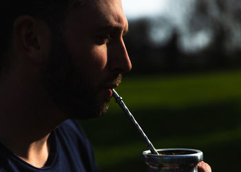 Portrait of young man drinking glasses outdoors