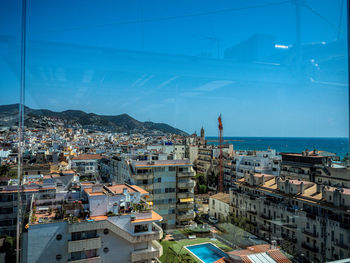 High angle view of townscape by sea against sky