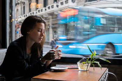 Young woman using drinking coffee in cafe
