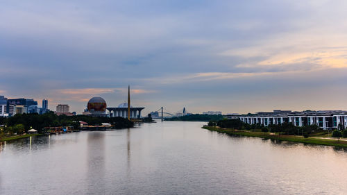 Bridge over river against buildings in city