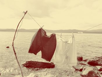 Clothes drying on beach against sky